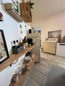 eine Küche mit einer Theke mit Geschirr darauf in der Unterkunft Le duo des Garennes - Entre confort & indépendance - Cour extérieure en centre ville de Blois in Blois