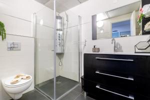 a bathroom with a toilet and a glass shower at King David Apartment - J&J in Jerusalem
