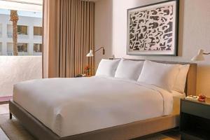 uma grande cama branca num quarto de hotel em The Monarch em Scottsdale