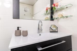 uma casa de banho com um lavatório e um espelho em King David Apartment - J&J em Jerusalém