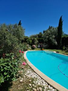 a swimming pool in a yard with flowers at Le Jardin Serein in Salindres