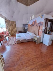 a bedroom with a bed with a mountain mural on the wall at Hasan Zawaideh Camp in Wadi Rum