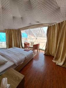 Hasan Zawaideh Camp في وادي رم: غرفة نوم بسرير وطاولة مع كراسي