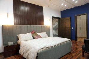 um quarto com uma cama grande e uma parede azul em Newly built Villa in Lahore em Lahore