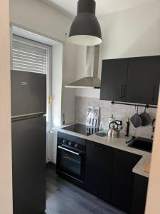 a kitchen with black appliances and a black refrigerator at Micheli Luxury Flat in Rome