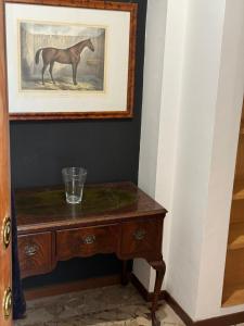 a painting of a horse on a wall next to a table at Micheli Luxury Flat in Rome