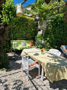 a table and chairs in a garden with a bench at Le Jardin Serein in Salindres