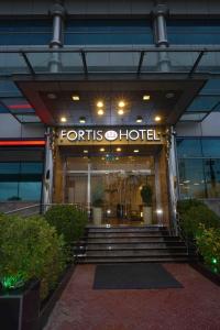 una entrada frontal a un edificio de estudios de los años 40 con escaleras en Fortis Hotel Fujairah, en Fujairah