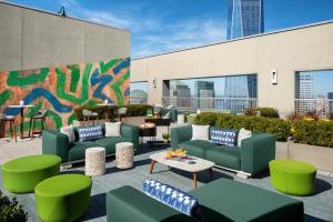 a patio with green couches and tables and a mural at Financial District 1br w WD gym elevator NYC-1370 in New York