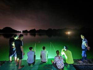 a group of people sitting on a dock at night at Tran Chau Garden Home in Cat Ba