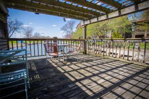 a deck with a table and chairs and a view of the water at Nuk's Executive Suites in De Pere