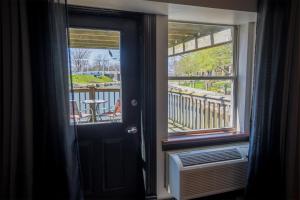 Zimmer mit einer Tür und einem Fenster mit einem Tisch in der Unterkunft Nuk's Executive Suites in De Pere