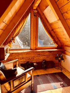 an attic room with a couch and a window at Mountain story apartment in Žabljak