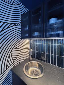 ein Bad mit einem Waschbecken in einer Wand in der Unterkunft WANDERLUST - Studio confort à 100m plage Solidor in Saint-Malo
