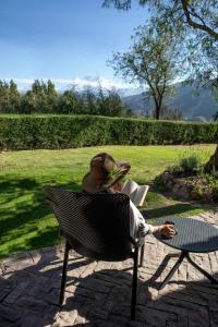 a woman sitting in a chair reading a book at Cuesta Serena Boutique Hotel in Huaraz