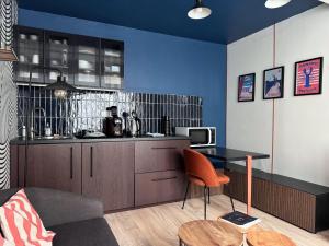 ein Wohnzimmer mit einem Tisch und einer Küche in der Unterkunft WANDERLUST - Studio confort à 100m plage Solidor in Saint-Malo