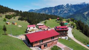 a house with a red roof on top of a hill at Kalispera Apart Otel in Uzungöl