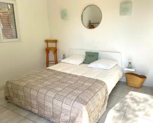 a bedroom with a bed and a mirror on the wall at Maison au calme avec jardin et parking, proche de tout ! in La Ciotat