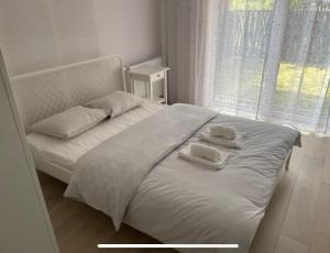 Una cama blanca con dos toallas encima. en Apartament Parking & Balkon, en Wroclaw