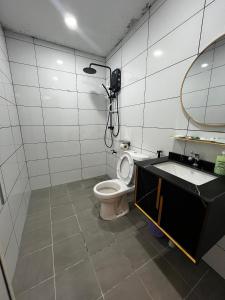 Un baño con inodoro, lavabo y espejo. en Halo Hotel, en Semporna 44 fotos más