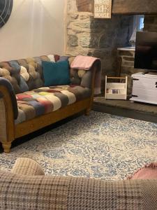 a living room with a couch and a tv at Hen Blas, 14th century 2 bedroom Cottage in Barmouth