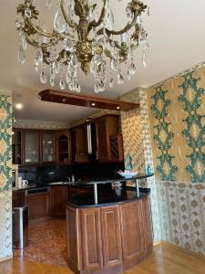 een keuken met een kroonluchter aan het plafond bij Emerald Suite in Praag