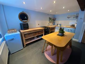a kitchen with a wooden table and a counter top at Hen Blas, 14th century 2 bedroom Cottage in Barmouth
