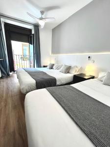 Habitación de hotel con 3 camas y ventana en Centric 3ºD, en Madrid