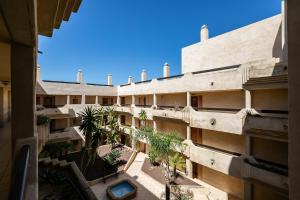 um edifício de apartamentos com um pátio com palmeiras em APARTAMENTO PREMIUM UN DORMITORIO na Isla Canela