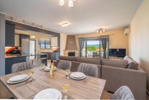 a dining room and living room with a table and chairs at Nicolis Seaside Apartment in Karavomylos