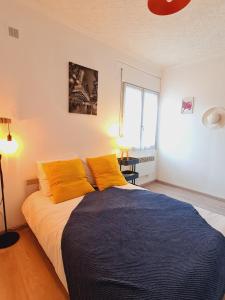 ein Schlafzimmer mit einem großen Bett mit gelben Kissen in der Unterkunft Les alouettes in Nanterre