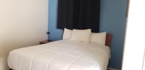 075B Affordable Retreat nr South Rim Sleeps 2 في فالي: غرفة نوم بسرير ابيض بجدار ازرق