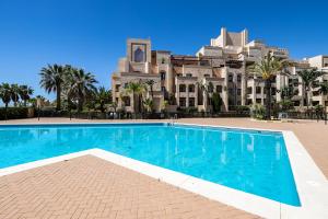 uma piscina em frente a um grande edifício em APARTAMENTO PREMIUM UN DORMITORIO na Isla Canela