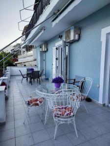 einen Glastisch und Stühle auf einer Terrasse in der Unterkunft Villa Violeta Lefkada Nydri in Nydri