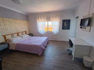 een slaapkamer met een bed, een bureau en een raam bij Hostal Bélgica in Palmanova