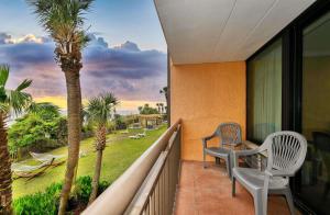 einen Balkon mit 2 Stühlen und einer Palme in der Unterkunft Caravelle Resort 219 in Myrtle Beach