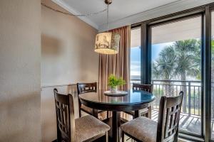 ein Esszimmer mit einem Tisch und Stühlen sowie einem großen Fenster in der Unterkunft Caravelle Resort 219 in Myrtle Beach