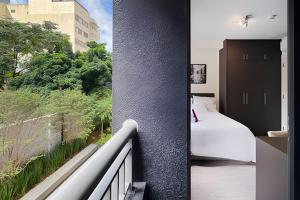 a hotel room with a bed and a balcony at Zainalofts7 Pinheiros - Z Pinheiros 107 in Sao Paulo