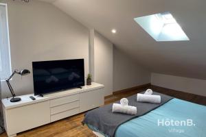 Large house close to city center Limoges في ليموج: غرفة نوم مع تلفزيون بشاشة مسطحة وسرير