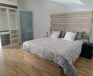 una camera con un grande letto con testiera in legno di Precioso Dúplex con terraza a 5 minutos playa y 20 minutos de Barcelona a Premiá de Mar