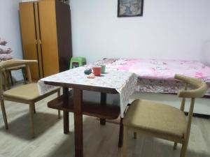 mesa y sillas con mesa y cama en Family Hotel Provide breakfast, en Subotica
