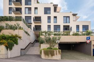 a large white building with stairs and plants at Luxury apartment Enjoyer - PRIVATE POOL with a large garden and private garage in Split