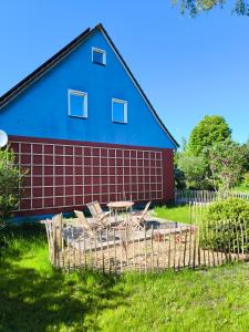 a blue and red house with a picnic table in front of it at Ferienhaus am Saaler Bodden in Saal