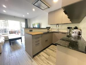 a kitchen with a counter top and a living room at Céntrico Apartmento in Platja d'Aro