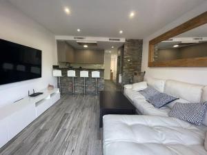 a living room with a white couch and a television at Céntrico Apartmento in Platja d'Aro