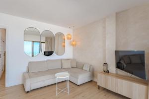 een woonkamer met een bank en een tv bij Panoramic view apartment in Los Gigantes in Acantilado de los Gigantes