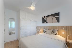 1 dormitorio blanco con 1 cama y ventilador de techo en Panoramic view apartment in Los Gigantes, en Acantilado de los Gigantes