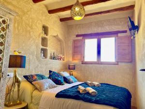 a bedroom with a bed with towels on it at El Kubo in Olba
