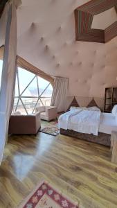 a large bedroom with a bed and a large window at Hasan Zawaideh Camp in Wadi Rum