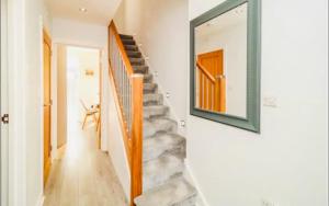 una escalera en una casa con un espejo en la pared en Whiteclouds, en Cheshunt